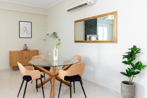 a dining room with a glass table and chairs at Helios Residence by A&D Properties in Porto Rafti