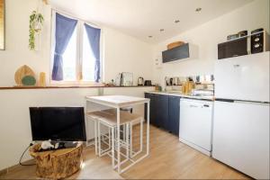 Una cocina con un refrigerador blanco y una mesa. en Maisonnette en pleine Campagne LA K-LINE, en Entrecasteaux 6 fotos más