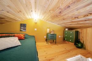 Un dormitorio con una cama y un techo de madera. en Maisonnette en pleine Campagne LA K-LINE, en Entrecasteaux