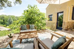 Un patio al aire libre con sillas y un árbol. en Maisonnette en pleine Campagne LA K-LINE, en Entrecasteaux