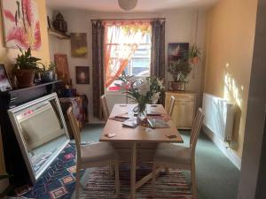 a dining room with a table and chairs and a window at Glastonbury 2-Bed House Sleeps 6 & Pet Friendly in Glastonbury