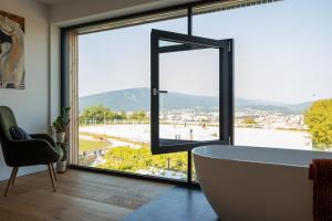 a bathroom with a tub and a large window at Hotel Frost in Maribor