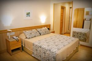 a bedroom with a bed and a table with a night stand at Hotel Regina Rio de Janeiro in Rio de Janeiro