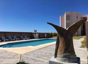 a statue of a bird next to a swimming pool at Complejo Saco Viejo in Las Grutas