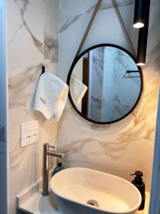 a bathroom with a sink and a mirror at Studio Pé na areia - Icaraí in Niterói +14 photos