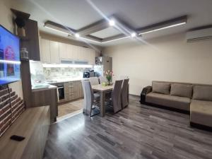 a kitchen and living room with a table and a couch at Luxurious flat - Pleven center in Pleven
