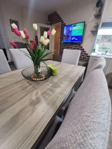 a wooden table with a vase of flowers on it at Luxurious flat - Pleven center in Pleven