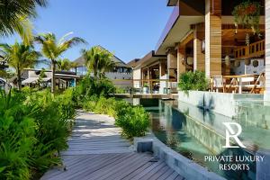 a resort with a swimming pool and palm trees at The Grand Luxxe Res Two Bedroom Loft- Riviera Maya in Nuevo Vallarta 