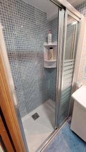 a shower with a glass door in a bathroom at Playa, relax y parking público cerca - Ideal parejas in Cullera +3 photos