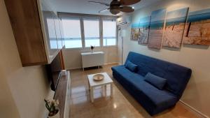 a living room with a blue couch and a table at Playa, relax y parking público cerca - Ideal parejas in Cullera