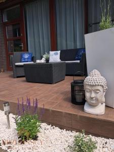 een standbeeld van een hoofd dat op een houten dek zit bij Apartament Blue Waves Wisełka in Wisełka