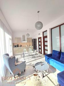 een woonkamer met een blauwe bank en een tafel bij Apartament Blue Waves Wisełka in Wisełka