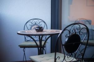 a small table with a camera on it next to two chairs at Hotel Frost in Maribor