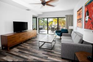 a living room with a couch and a flat screen tv at The Perry Hotel & Marina Key West in Key West