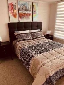Un dormitorio con una cama grande con dos mesitas de noche. en Almanova Sunset, en Antofagasta