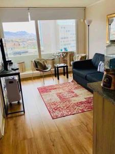 Una sala de estar con un sofá azul y una alfombra roja. en Almanova Sunset, en Antofagasta