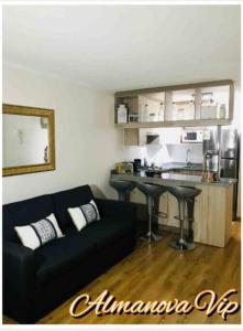 Una sala de estar con un sofá negro y una mesa. en Almanova Sunset, en Antofagasta