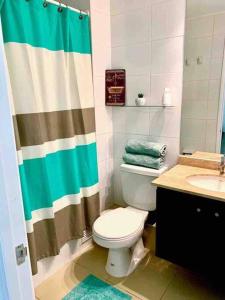 Un baño con inodoro y cortina de ducha. en Almanova Sunset, en Antofagasta 24 fotos más