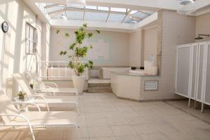 a bathroom with white chairs and a bath tub at Hotel Regina Rio de Janeiro in Rio de Janeiro