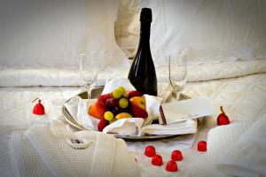 a plate of fruit and a bottle of wine on a bed at Hotel Regina Rio de Janeiro in Rio de Janeiro