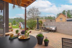 a patio with a black table and potted plants at B&B de Groene Poort in Stein +11 photos