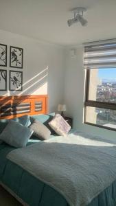 a bedroom with a bed with pillows and a window at Hermoso Departamento en Los Angeles in Los Ángeles