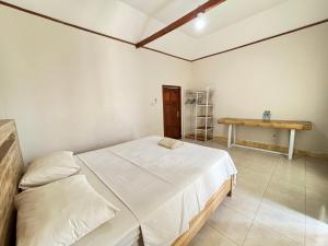 a bedroom with a bed and a table in it at Krisna Bungalows and Restaurant in Sekotong