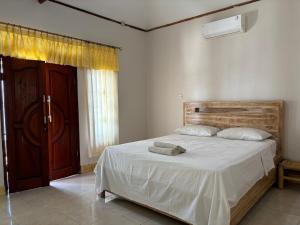 a bedroom with a bed with two towels on it at Krisna Bungalows and Restaurant in Sekotong