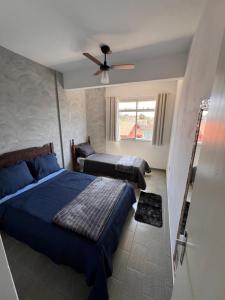 a bedroom with two beds and a ceiling fan at Ape Vista Mar in Guarapari