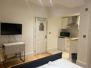 a kitchen with a white door with a television on it at Hyde Park Studio Apartments in London +19 photos