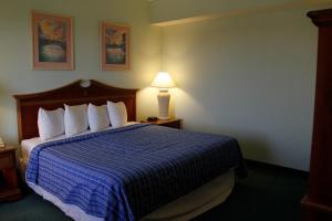 Habitación de hotel con cama con manta azul en Cocoa Beach Suites Hotel en Cocoa Beach