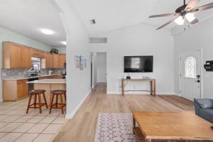 Una cocina y una sala de estar con un sofá y una mesa. en Jax Beach Getaway 5 Minute Walk to the Waves, en Jacksonville Beach