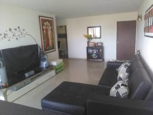 Una sala de estar con un sofá y un televisor de pantalla plana. en ideal para vacaciones o trabajo, en Cumaná