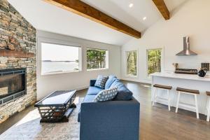un soggiorno con un divano blu e un camino di Waterfront Roque Bluffs Hideaway with Private Beach a Machias Altre 20 foto