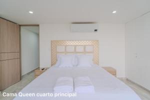 a bedroom with a large white bed with white pillows at lujoso apartamento familiar frente al mar in Cartagena de Indias