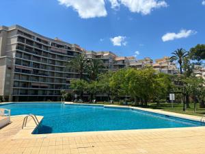a swimming pool in front of a large apartment building at Relax en playa de l'Ahuir Gandia in Playa de Gandia