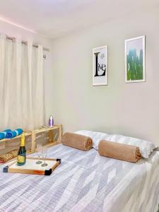 a bedroom with a bed with a bottle and glasses on it at Apê Aconchegante com Piscina I Wi-Fi e A/C in Imperatriz +34 photos