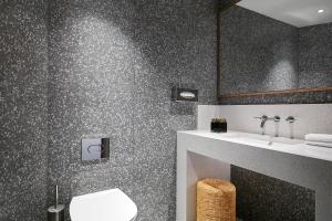 a bathroom with a toilet and a sink at Malta Marriott Resort & Spa in St. Julianʼs