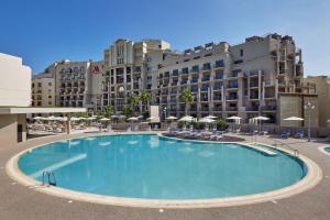 a large swimming pool in front of a hotel at Malta Marriott Resort & Spa in St. Julianʼs