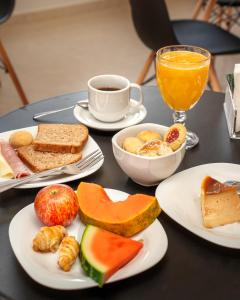 einen Tisch mit Tellern und einer Tasse Kaffee in der Unterkunft Pousada Canto da Montanha in São Thomé das Letras