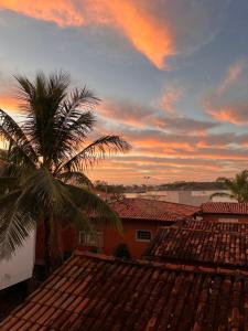 a palm tree on the roof of a house with a sunset at Ape Vista Mar in Guarapari