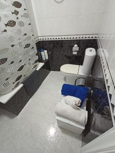 a bathroom with a toilet and a blue towel at Cesuresrooms1 in Puentecesures +20 photos