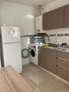 eine Küche mit einem weißen Kühlschrank und einer Waschmaschine in der Unterkunft Cálido departamento centrico. in Barraquero