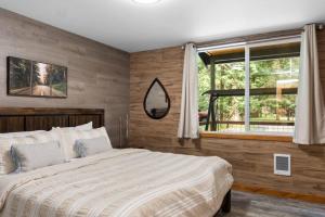 a bedroom with a large bed and a window at Luxe Chalet at Rainier Entrance with Hot Tub-AC-WiFi in Ashford