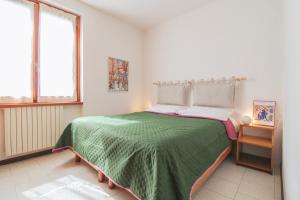 a bedroom with a large bed with a green blanket at Villa Sanziana in Menaggio