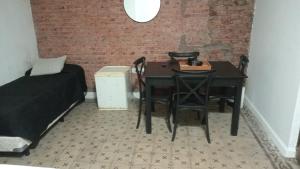 a bedroom with a table and chairs next to a brick wall at Pucara Apart - Habitaciones con baño privado in Corrientes