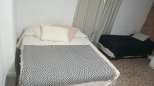an empty bed in a room with a window at Pucara Apart - Habitaciones con baño privado in Corrientes +5 photos