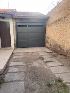 eine Garage mit einer Tür an der Seite eines Gebäudes in der Unterkunft Cálido departamento centrico. in Barraquero