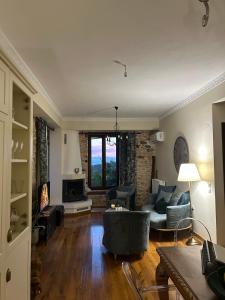 a living room with a couch and chairs and a fireplace at Αρχοντικό Νόνη in Mileai