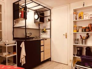 a kitchen with a black and white kitchen at Cozy and nice homestay room - chambre d'hôte in Paris